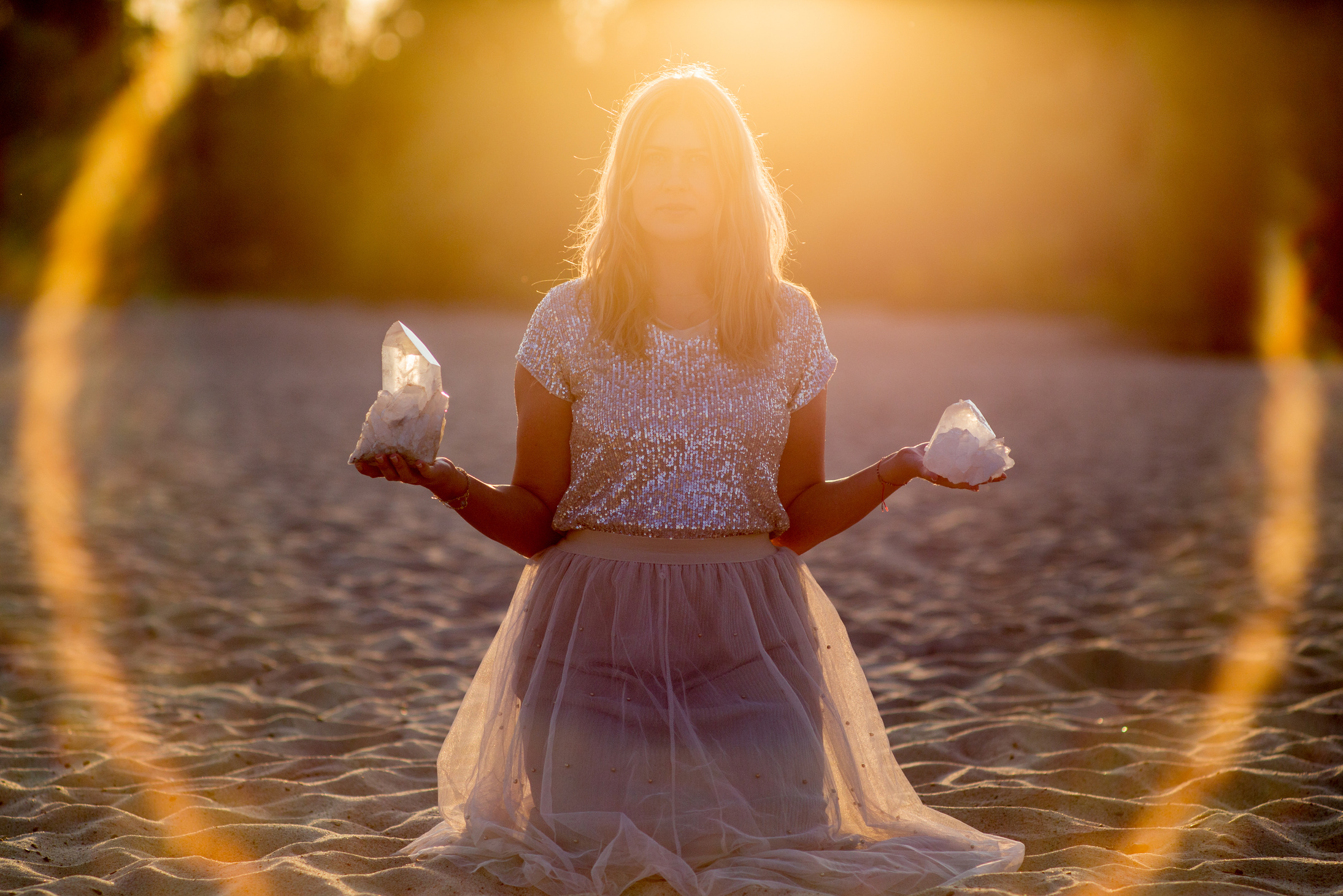 Beautiful woman on beach holding healing crystals